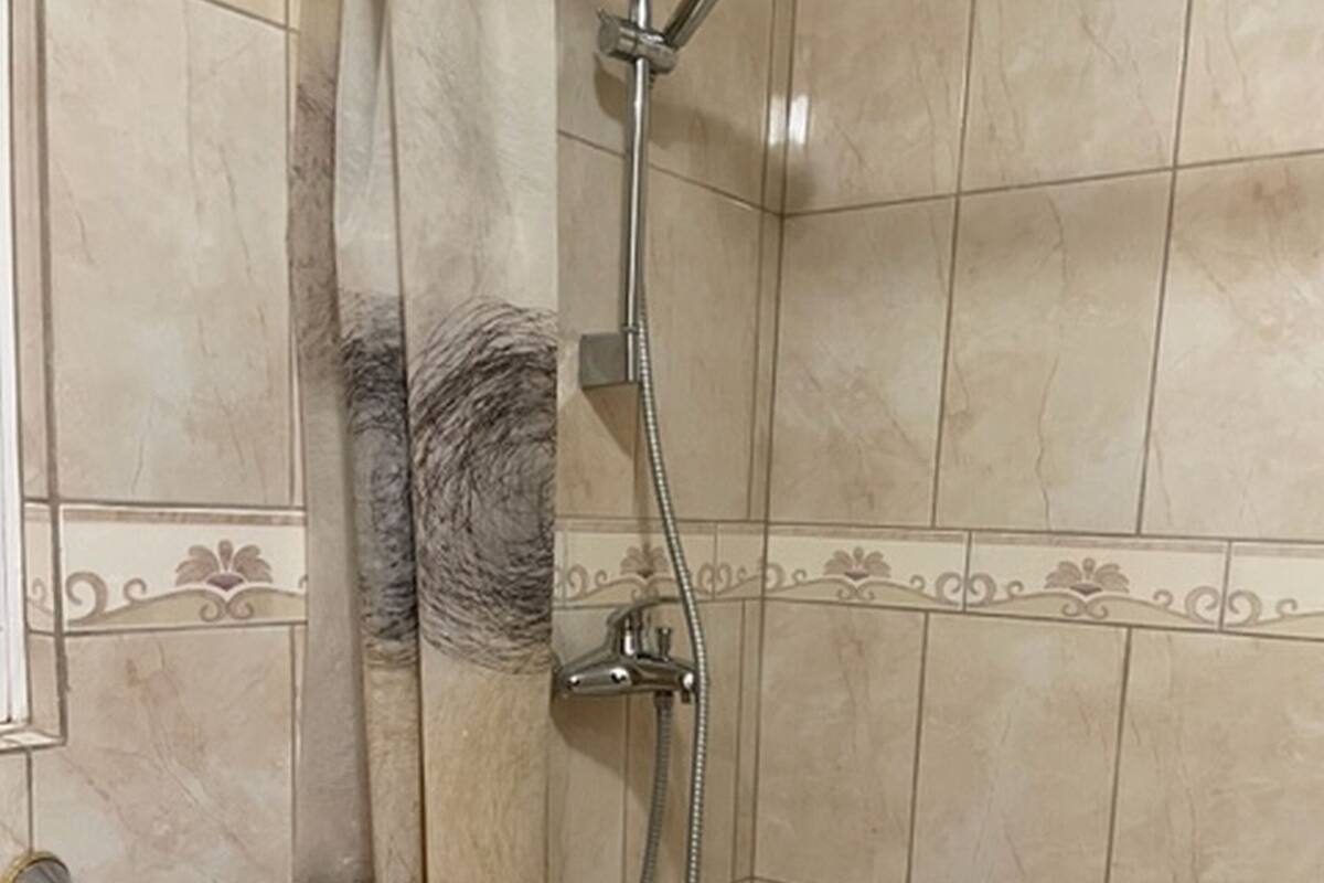Ein Duschbereich mit Handbrause und Wandarmatur.