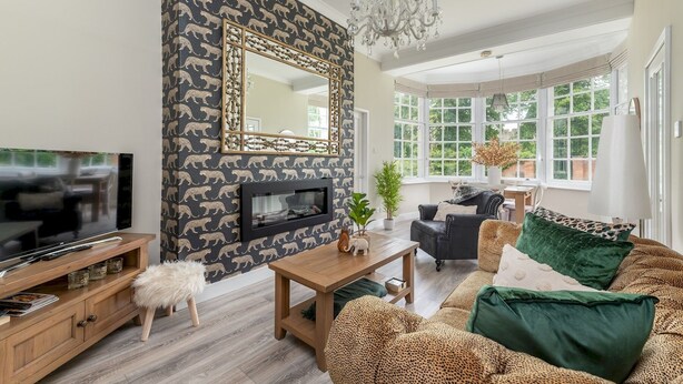 A living room with a fireplace, a television, a sofa, and a dining area. - 3 Feversham House · Spacious 1-Bed Apartment in the Heart of York- Pass the Keys (York)