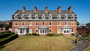 A large, red-brick building with multiple windows and a well-maintained lawn. - 3 Feversham House · Spacious 1-Bed Apartment in the Heart of York- Pass the Keys (York)