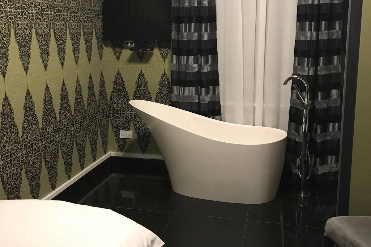 A modern bathroom with a freestanding bathtub, a toilet, and a sink.