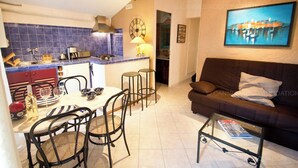 A compact living space with a kitchen, dining area, and a sofa. - Maillot-0008-Provençal charm inside and outside (Cannes)