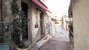 A narrow street with buildings on either side, featuring a red awning and a potted plant. - Maillot-0008-Provençal charm inside and outside (Cannes)