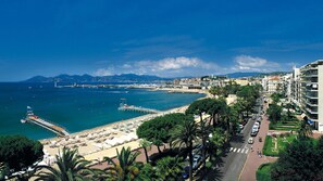 A coastal cityscape with a marina, beach, and urban buildings.