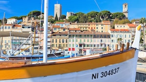 Ein Boot mit der Nummer NI 304837 liegt in einer Marina vor bunten Gebäuden und einem Turm im Hintergrund.