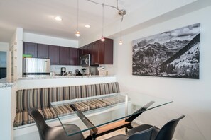 A modern kitchen with dark cabinets, stainless steel appliances, and pendant lighting. - Deluxe Unit with Unbeatable Deck Views (Telluride)