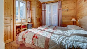 Ein Zimmer in einer Holzhütte mit einem Bett, einem Schreibtisch und einem Stuhl.