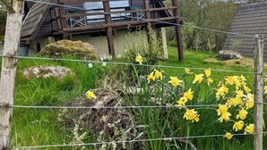 A cabin with a wooden deck and a large window. - Glen Lodges (Rogart)