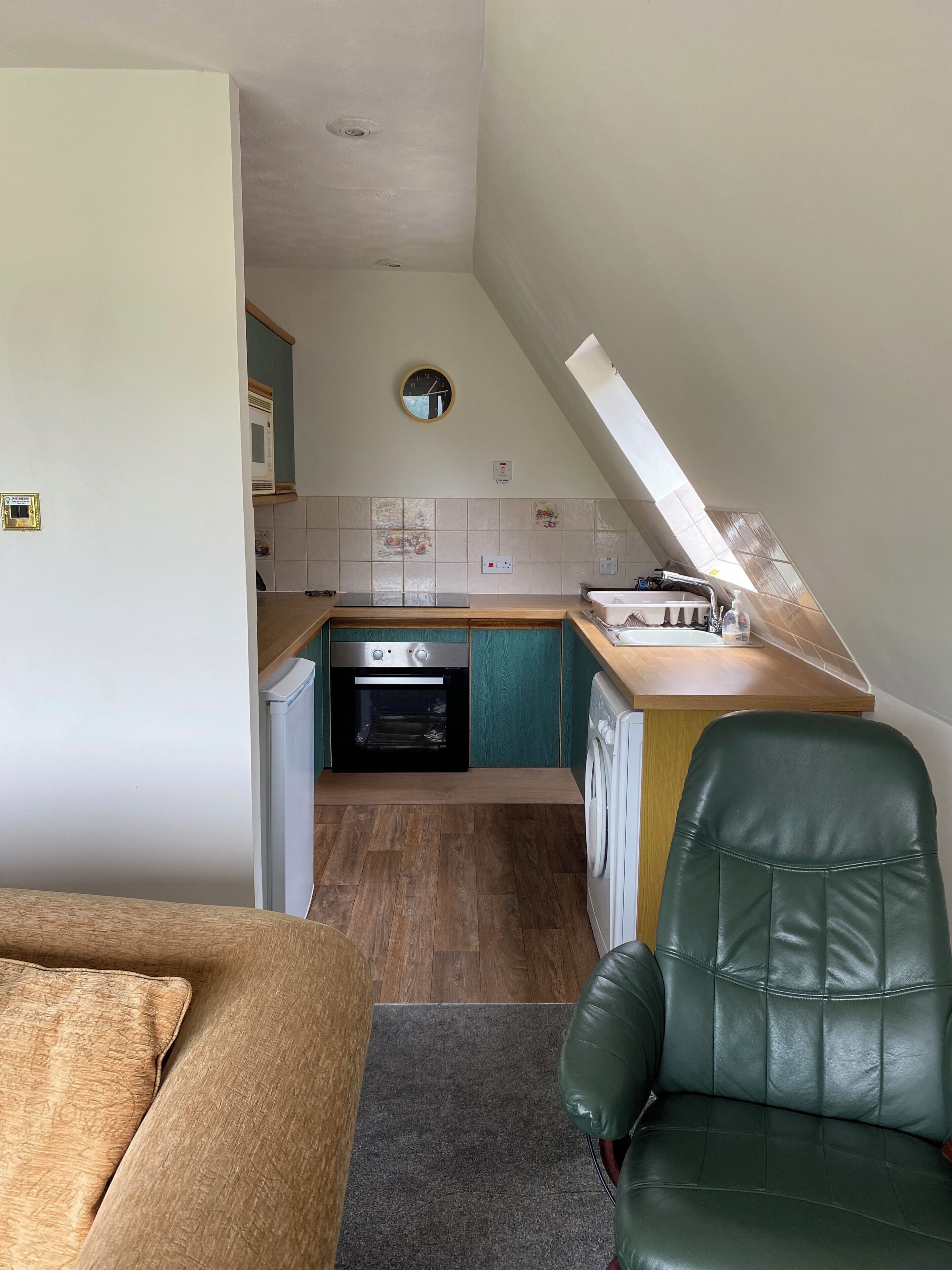 A compact kitchen with a built-in oven, a washing machine, and a small countertop.