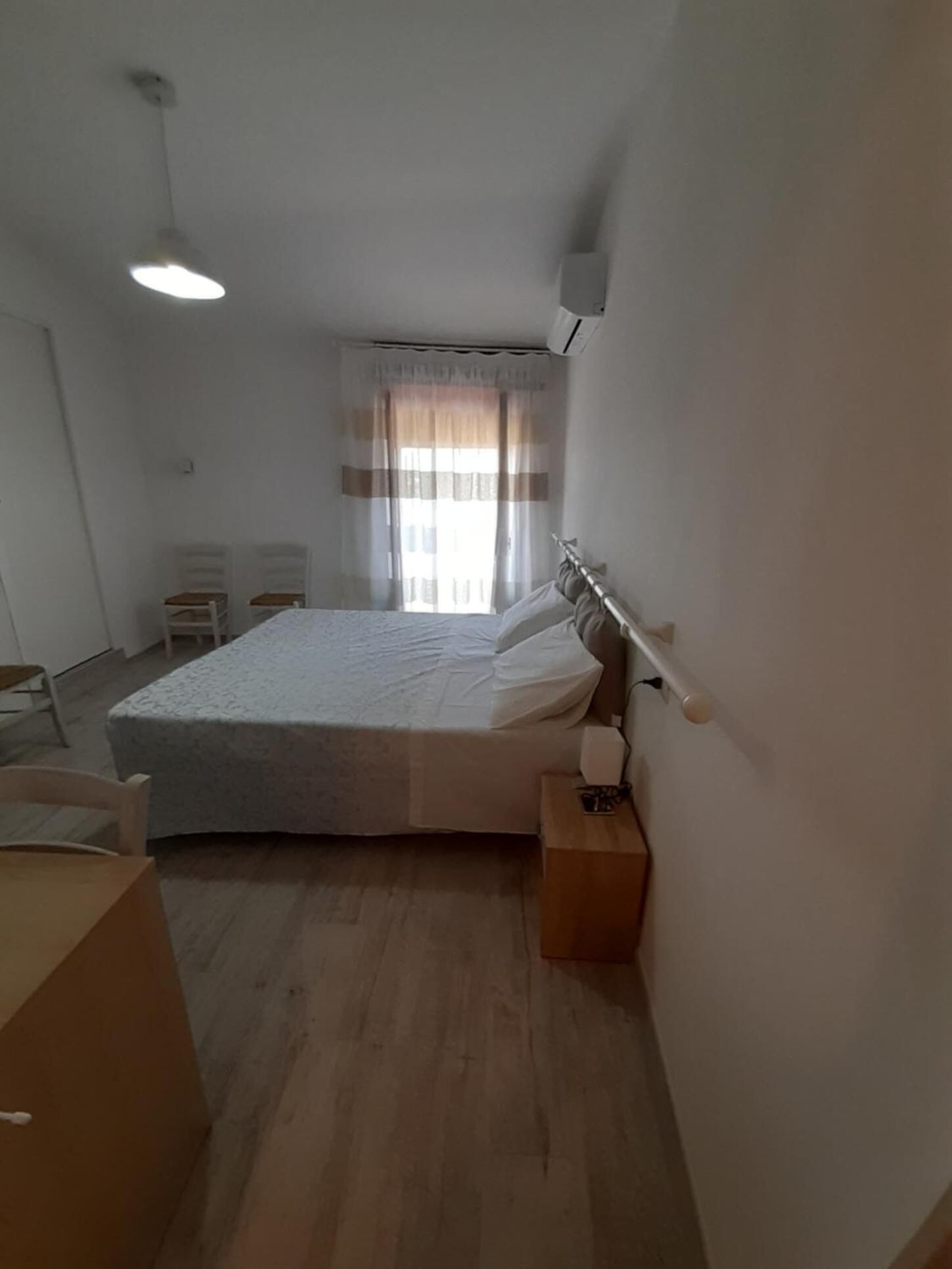 Une chambre à coucher avec un lit, une table de chevet et un bureau.