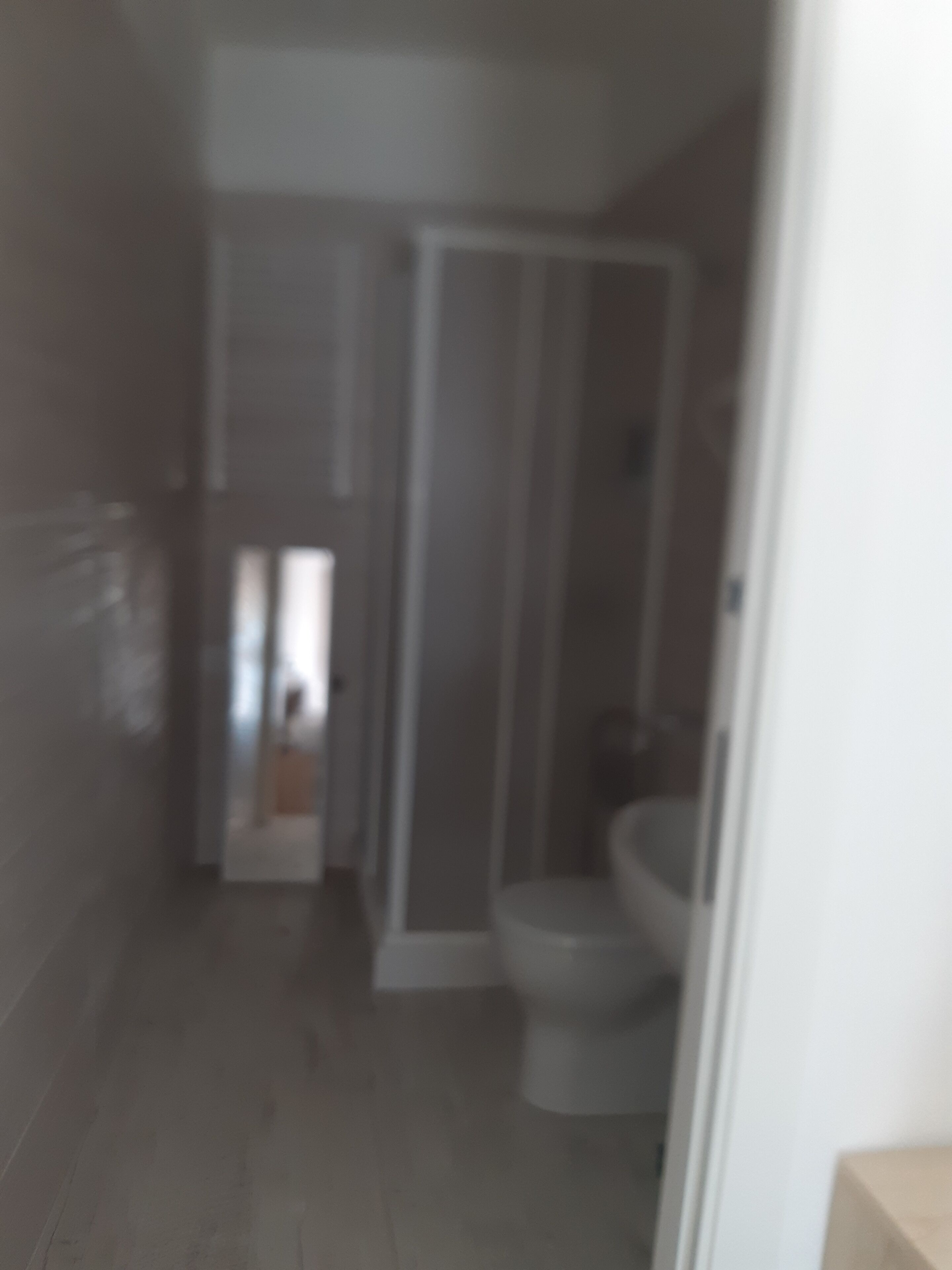 A bathroom with a toilet and a shower stall.