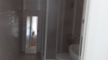 A bathroom with a toilet and a shower stall.
