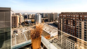 A high-rise building with a view of a cityscape, including various buildings and a parking lot. - Bluebird Suites in Pentagon City (Arlington)