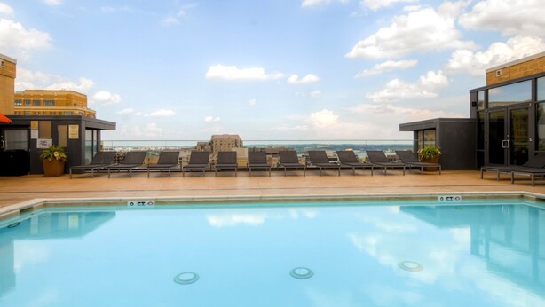 A rooftop pool with lounge chairs and a view of the sea. - Bluebird Suites in Pentagon City (Arlington)