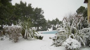 A snowy outdoor area with a pool, surrounded by snow-covered bushes and trees. - Locanda Strada Della Marina (Senigallia)