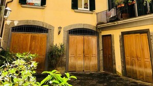 A yellow building with multiple balconies, wooden doors, and a stone archway. - Palazzo Rota Guesthouse (Naples)