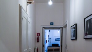A hallway with wooden flooring, white walls, and doors leading to other areas. - GuestHouse Marcanto - Duomo (Naples)