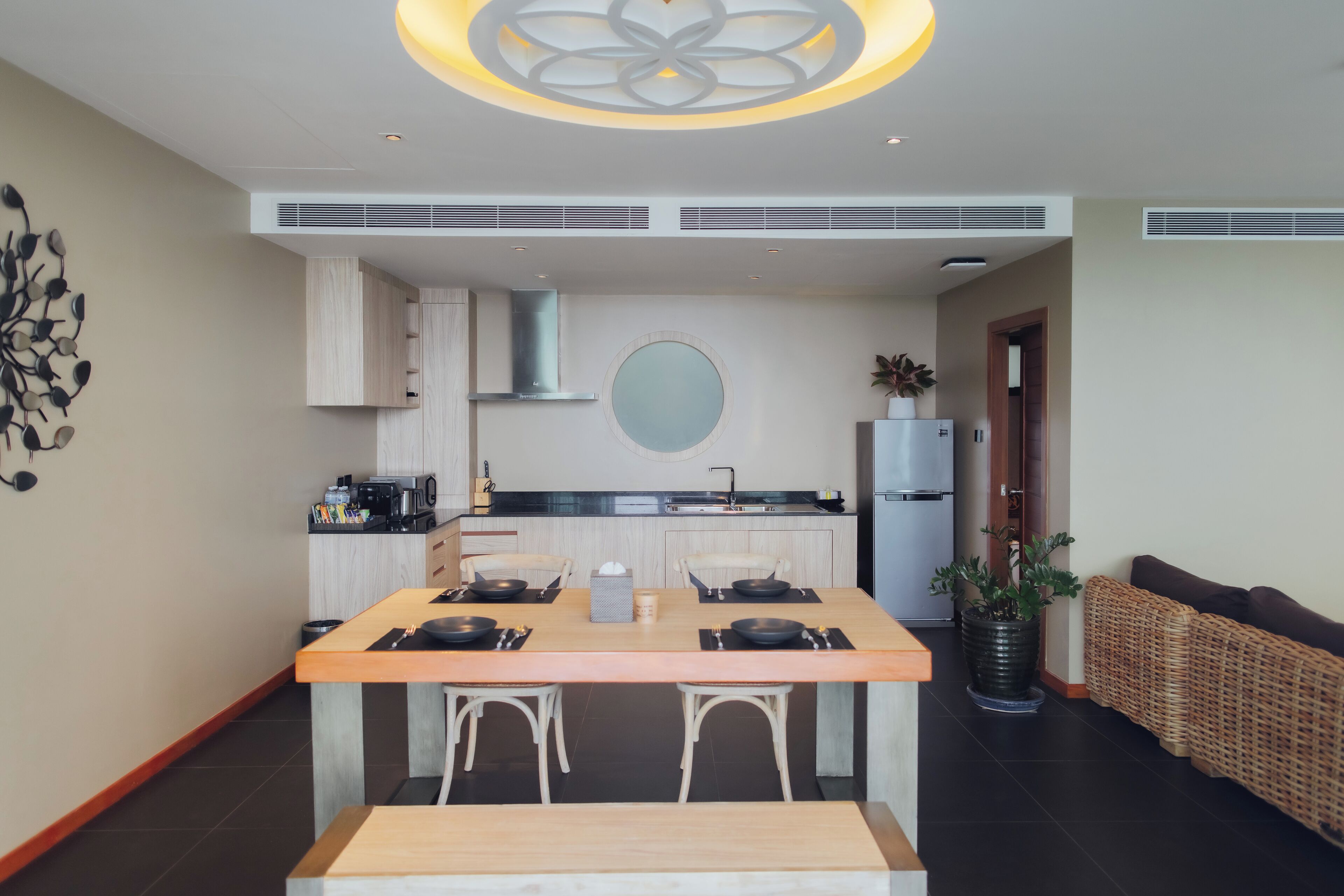 A modern kitchen with a central island, built-in cabinets, and a round mirror above the sink.