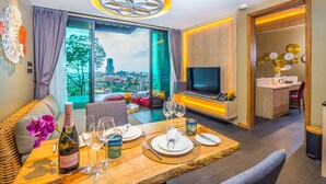 Ein modernes Hotelzimmer mit Essbereich, Fernseher und Blick auf die Stadt.