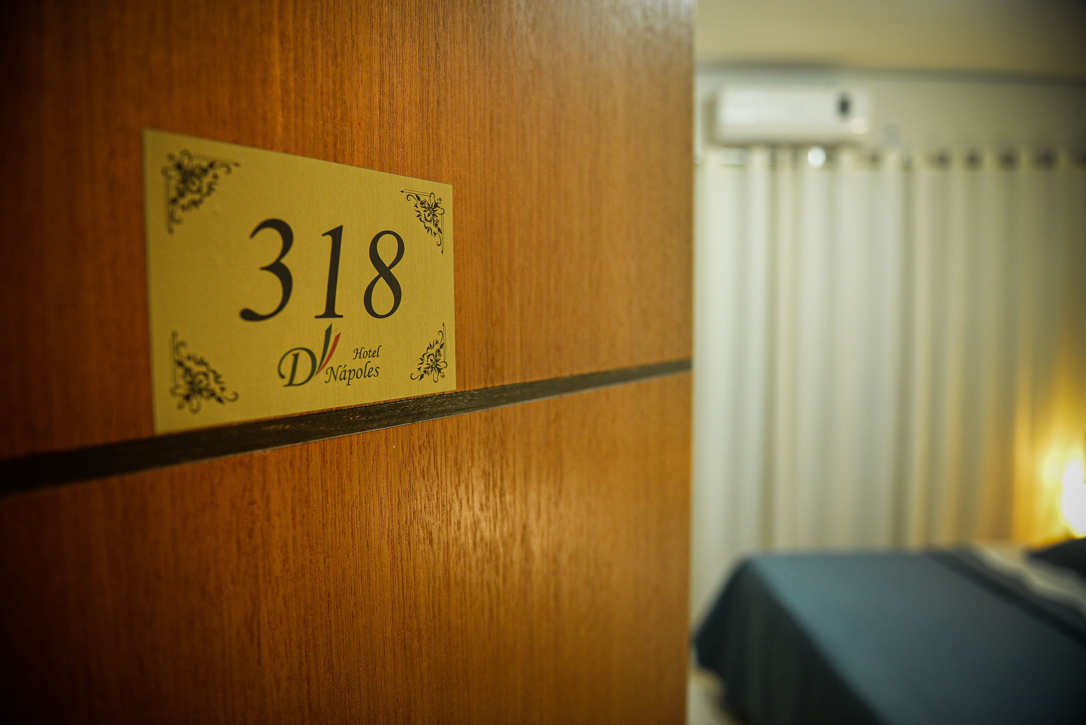 Puerta de habitación de hotel con un cartel que indica el número 318.