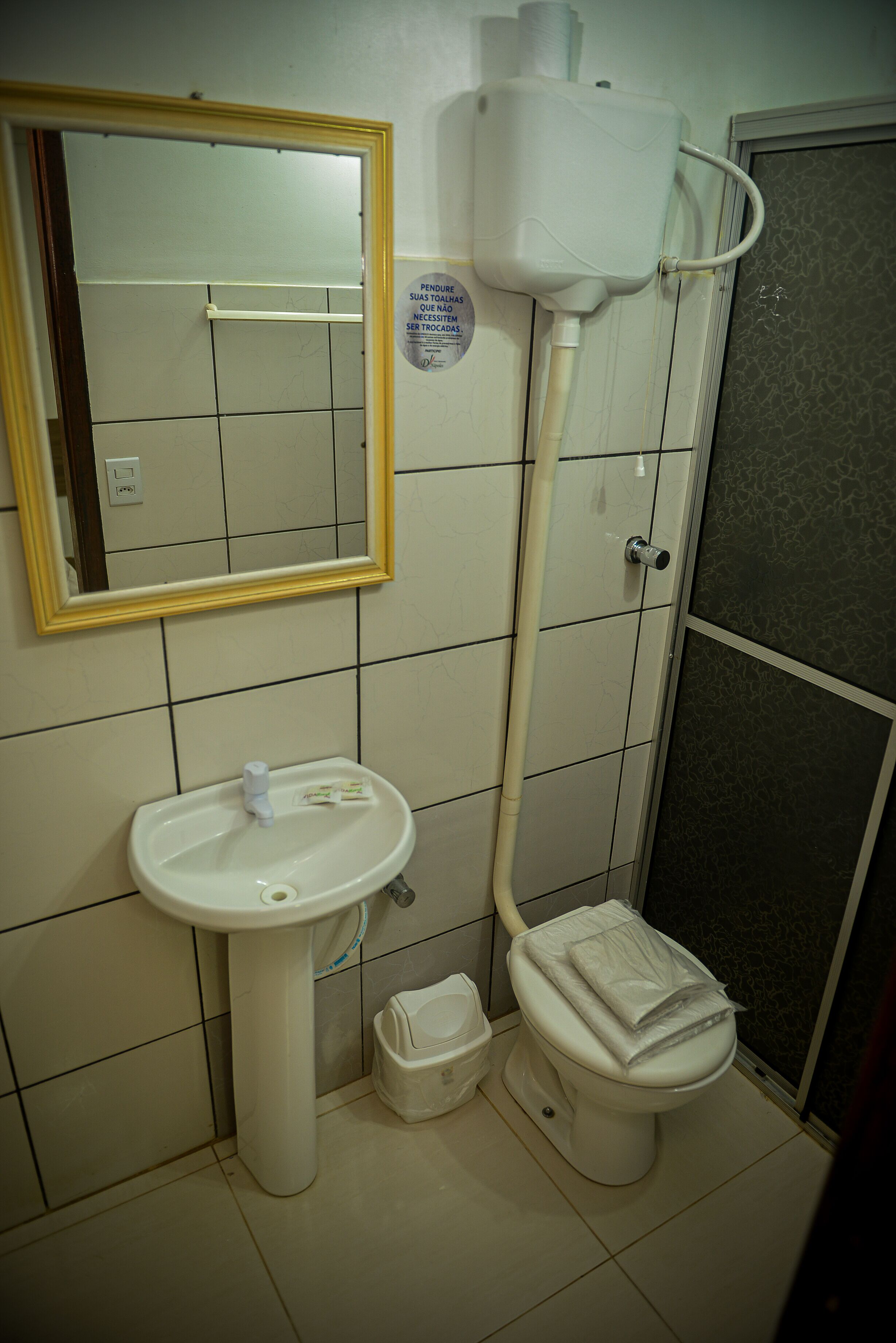 A bathroom with a sink, toilet, and a mirror.