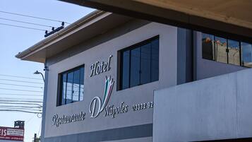 Un letrero de hotel con el nombre 'Hotel Restaurante Nápoles' y un número de teléfono.