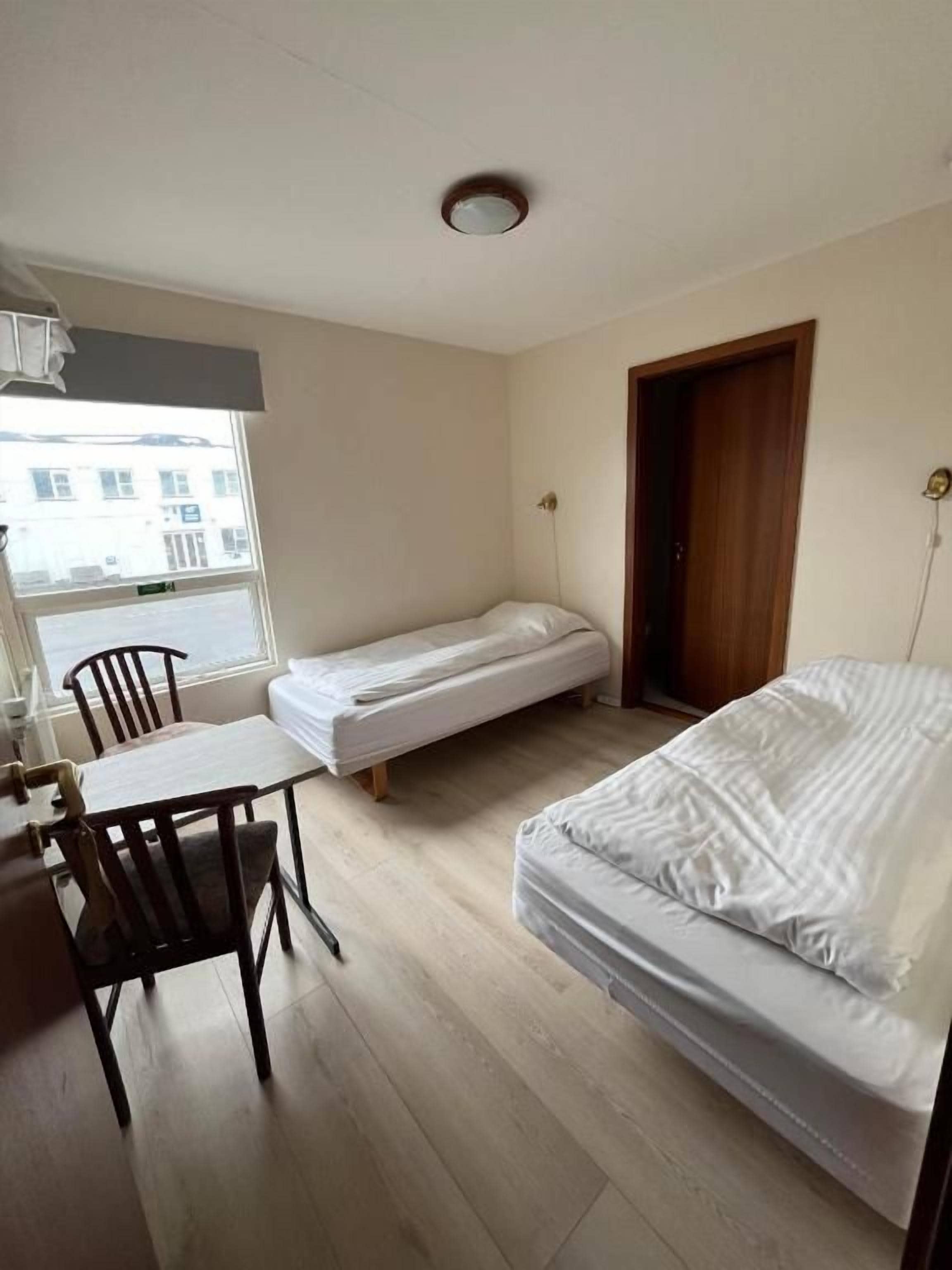 Una habitación pequeña con una cama, un escritorio y una silla.