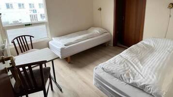 Una habitación pequeña con una cama, un escritorio y una silla.