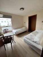 A small room with a bed, a desk, and a chair.