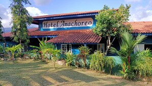 Hotel Anachoreo with a corrugated metal roof, surrounded by tropical vegetation. - Hotel Anachoreo (Santa Fe)