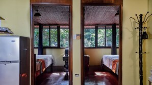 A room with two beds, a refrigerator, and a coat rack. - Hotel Anachoreo (Santa Fe)