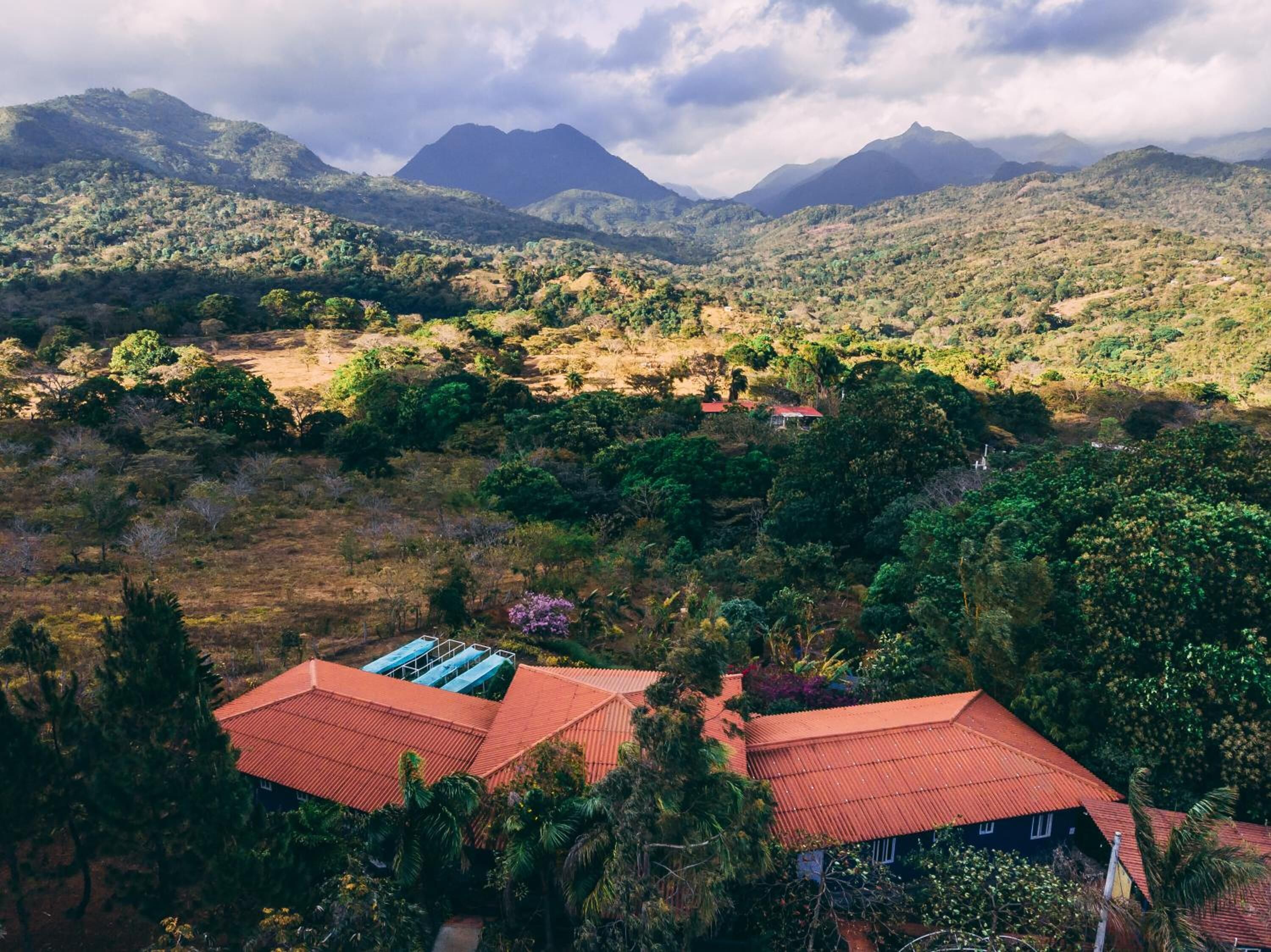 A mountainous landscape with scattered houses and lush greenery.