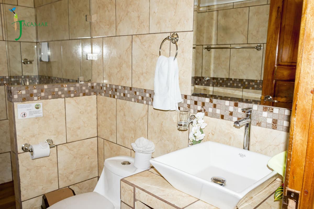 A bathroom with a bathtub, toilet, and a mirror.