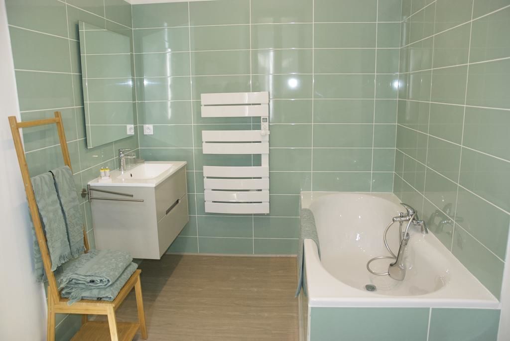 Une salle de bain avec un lavabo, un miroir et une baignoire.