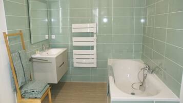 Un baño con lavabo, espejo y bañera.