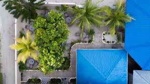 Eine Übersichtsansicht eines Resorts mit Poolbereich, Sitzgelegenheiten im Freien und Palmen.