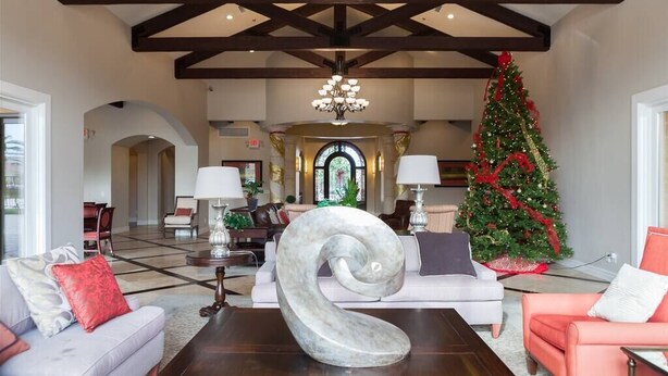 Um hall amplo com um lustre imponente, uma árvore de Natal e decoração moderna.