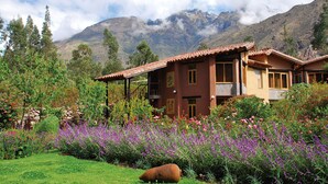 A house with a garden in front, surrounded by mountains. - Willka T'ika Essential Wellness (Urubamba)