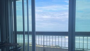 A balcony with a view of the sea, a table with chairs, and a tiled floor. - Luxury studio 1st line Ocean for 2 persons (Biarritz)