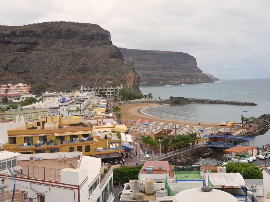 Un pueblo costero con playa, edificios y acantilados.