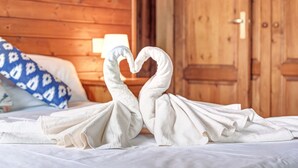 Een bed met een handdoekje gerangschikt in de vorm van een hart.