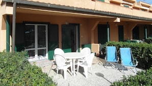 A building with a covered patio area, outdoor seating, and a satellite dish. - Apartment "Golfo Stella" With Sea View and Near the Sea (CAPOLIVERI)