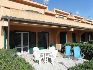 Ein Gebäude mit einer überdachten Terrasse, Außenbestuhlung und einer Satellitenschüssel.