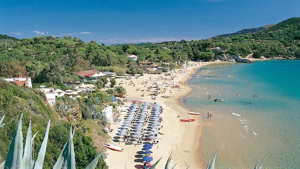 A beach with rows of umbrellas, a sandy shore, and a hilly backdrop. - Apartment "Golfo Stella" With Sea View and Near the Sea (CAPOLIVERI)