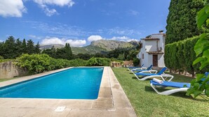 A swimming pool with lounge chairs, a small building, and a mountainous backdrop. - Villa "La Plana" with Stunning Mountain Panorama and Pool (Pollensa)