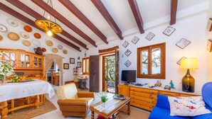 Una sala de estar acogedora con una mesa de madera, un sofá azul y un televisor.