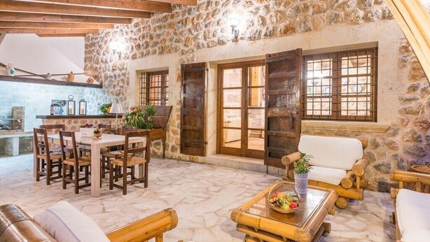 A rustic interior with stone walls, wooden furniture, and a stone fireplace. - Villa with mountain view and pool - Es Puchet (Alcudia)
