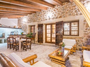 Un interior rústico con paredes de piedra, muebles de madera y una chimenea de piedra.