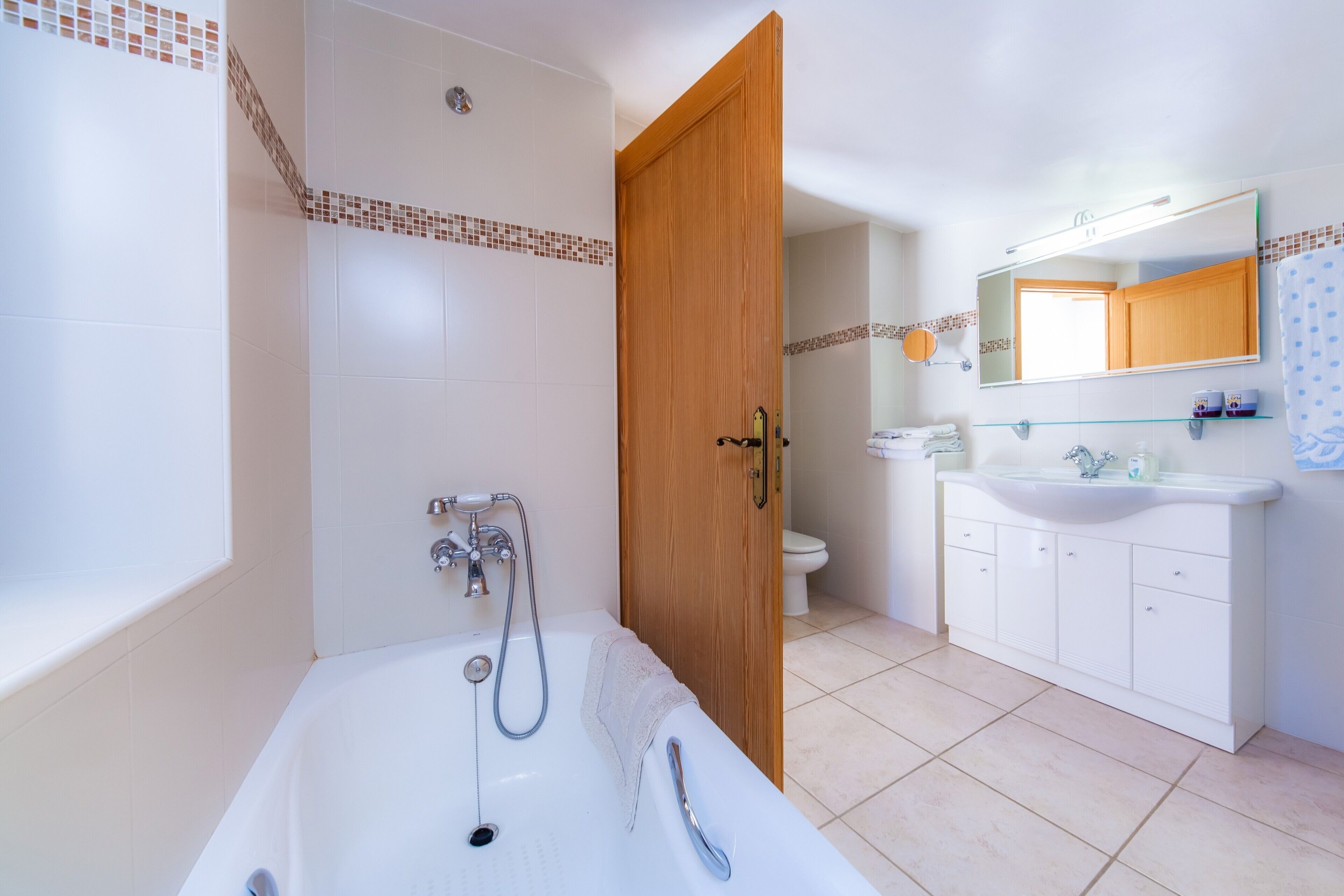 A bathroom with a bathtub, shower, toilet, and sink.