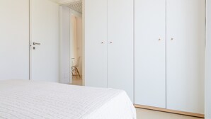 Une chambre à coucher avec un lit, une armoire et une chaise.
