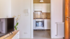 Une cuisine moderne avec des armoires blanches, un four encastré et une cuisinière.